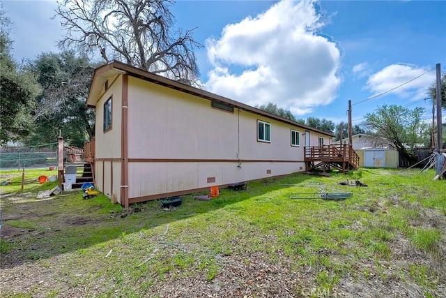 exterior space with a yard, an outbuilding, a shed, and fence