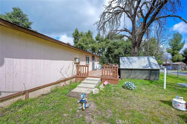 view of yard featuring a wooden deck and an outbuilding