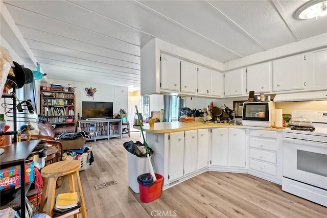 kitchen with white cabinets, white range with gas cooktop, under cabinet range hood, light wood-type flooring, and open floor plan