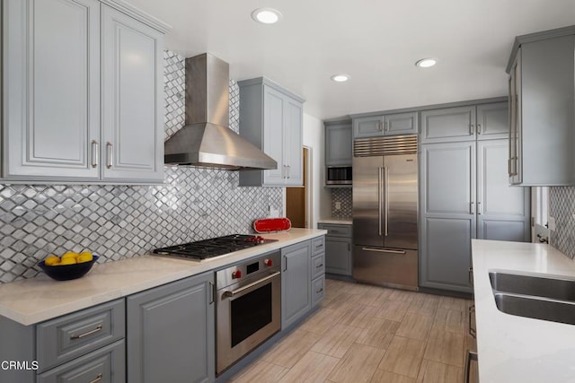 1441 Cleveland Rd, Glendale, CA 91202 - kitchen with recessed lighting, stainless steel appliances, gray cabinetry, backsplash, and wall chimney range hood