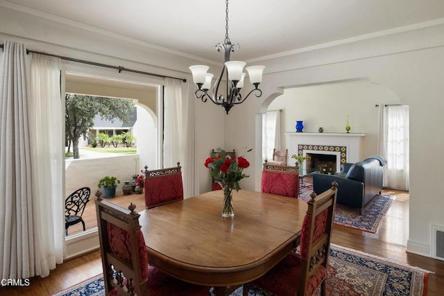 1441 Cleveland Rd, Glendale, CA 91202 - dining area featuring plenty of natural light, arched walkways, a chandelier, and wood finished floors