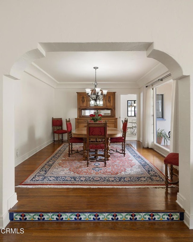 1441 Cleveland Rd, Glendale, CA 91202 - dining room with ornamental molding, baseboards, a chandelier, arched walkways, and wood finished floors