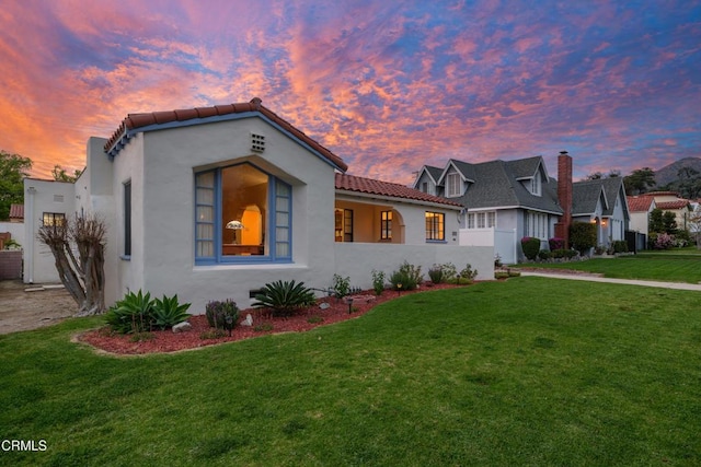 1441 Cleveland Rd, Glendale, CA 91202 - mediterranean / spanish-style home featuring stucco siding, a tiled roof, and a yard