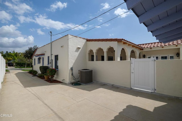1441 Cleveland Rd, Glendale, CA 91202 - view of home's exterior with a tile roof, a gate, cooling unit, stucco siding, and fence