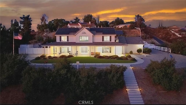 41559 Floyd Ct, Temecula, CA 92592 - back of house at dusk featuring roof mounted solar panels and covered porch