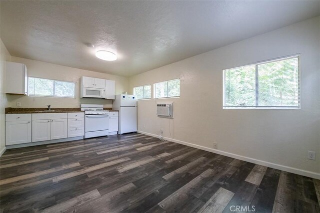 282 E 8th St, Chico, CA 95928 - kitchen with white appliances, baseboards, dark countertops, and a wall mounted air conditioner