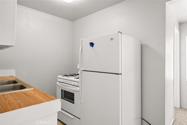 282 E 8th St, Chico, CA 95928 - kitchen featuring white appliances, wood counters, and a sink