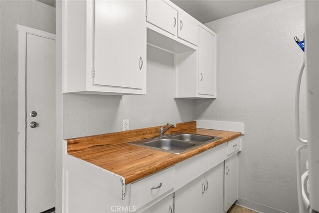 282 E 8th St, Chico, CA 95928 - kitchen featuring a sink, white cabinets, and freestanding refrigerator