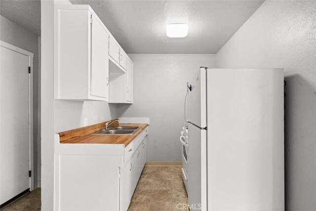 282 E 8th St, Chico, CA 95928 - kitchen featuring freestanding refrigerator, white cabinets, a sink, and light countertops