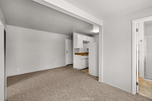 282 E 8th St, Chico, CA 95928 - unfurnished living room featuring a textured wall and light colored carpet