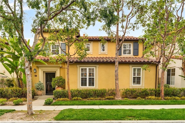 mediterranean / spanish-style house featuring a tile roof and stucco siding