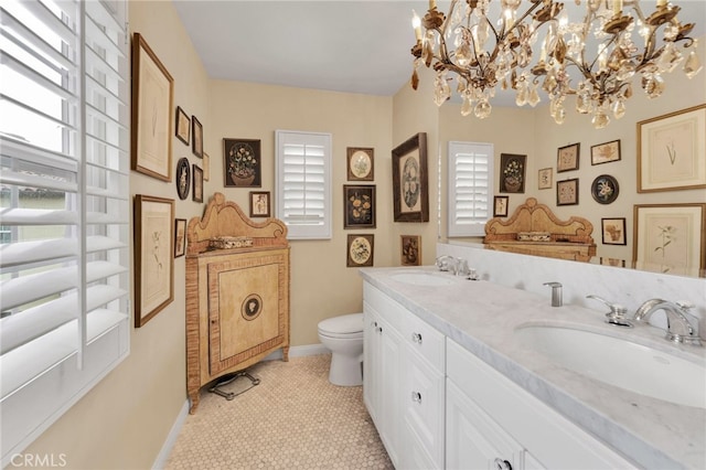 full bathroom featuring baseboards, a sink, toilet, and a chandelier
