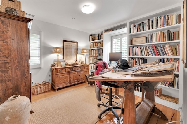 home office with light wood finished floors and visible vents