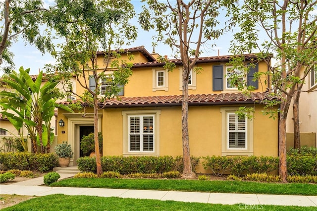 mediterranean / spanish home with stucco siding and a tile roof
