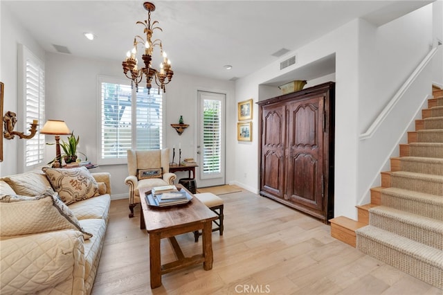 living room with visible vents, stairs, recessed lighting, light wood-style floors, and an inviting chandelier