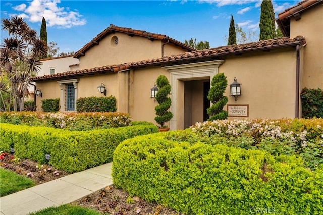 mediterranean / spanish house featuring stucco siding and a tile roof
