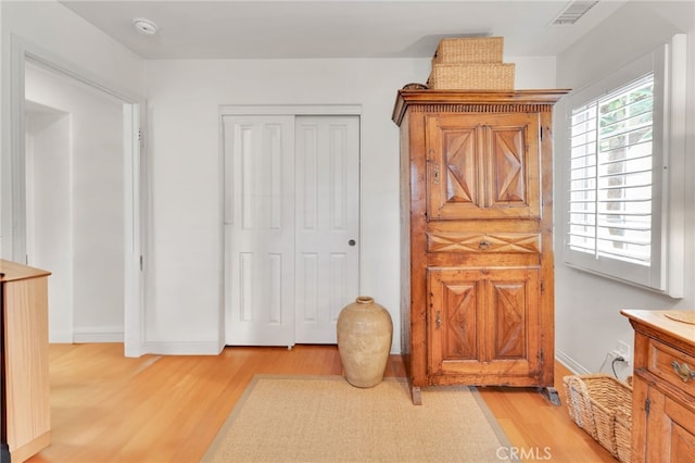 interior space featuring baseboards, visible vents, and light wood-type flooring