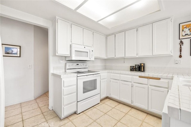 kitchen featuring white cabinets, tile counters, light tile patterned floors, and white appliances