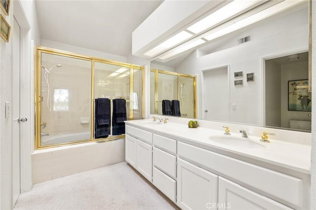 bathroom with vaulted ceiling, a sink, visible vents, double vanity, and tiled shower / bath