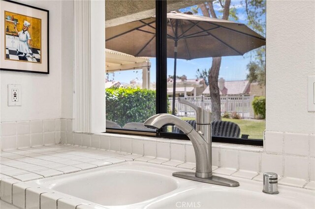 interior details featuring tile countertops and a sink