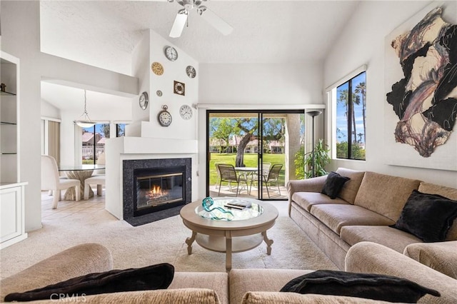 carpeted living area with a fireplace with flush hearth, lofted ceiling, and ceiling fan