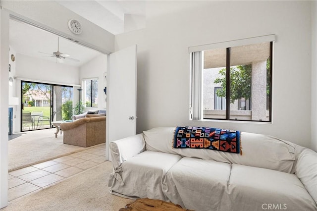 living room featuring vaulted ceiling, ceiling fan, carpet, and tile patterned flooring