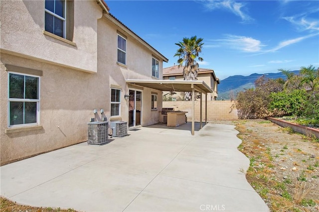 view of patio with a mountain view, fence, and cooling unit
