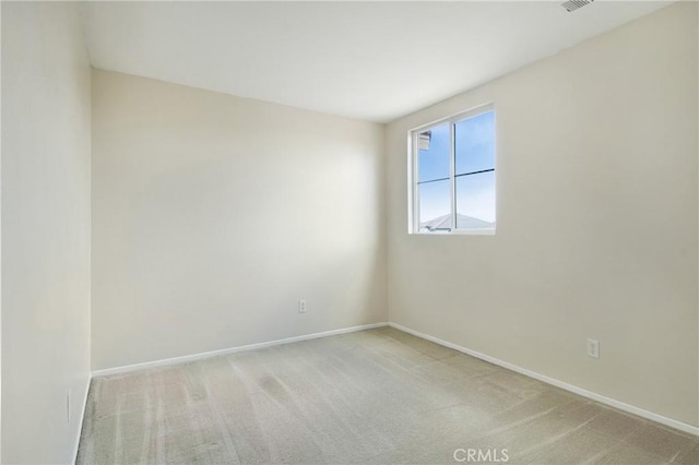 carpeted empty room with visible vents and baseboards