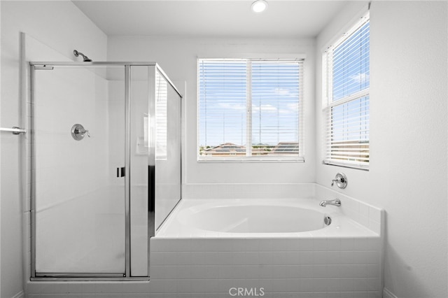 full bathroom featuring a shower stall and a garden tub