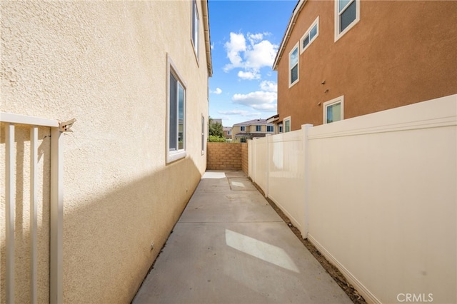 view of property exterior with fence, a patio, and stucco siding
