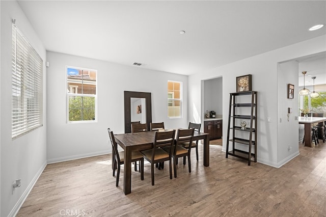 dining room with visible vents, baseboards, and wood finished floors