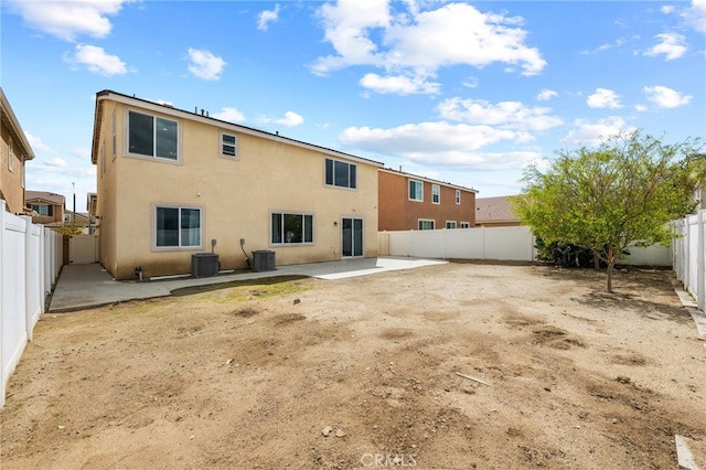 rear view of house with a patio area, stucco siding, a fenced backyard, and central AC