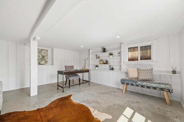 office space featuring concrete flooring and a decorative wall