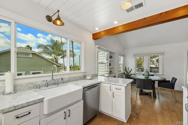 kitchen featuring white cabinets, visible vents, a sink, vaulted ceiling with beams, and stainless steel dishwasher