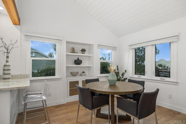 dining room featuring built in features, baseboards, high vaulted ceiling, and wood finished floors