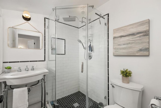 full bath with a sink, toilet, a shower stall, and tasteful backsplash