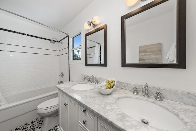 bathroom featuring double vanity, a sink, toilet, and shower / tub combo