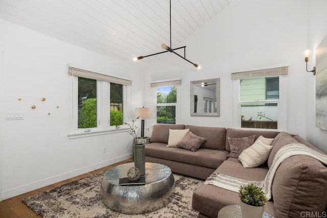 living area featuring baseboards, wood finished floors, lofted ceiling, an inviting chandelier, and wood ceiling