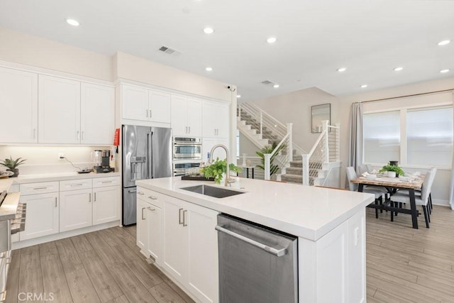 kitchen with visible vents, a sink, light countertops, appliances with stainless steel finishes, and white cabinetry