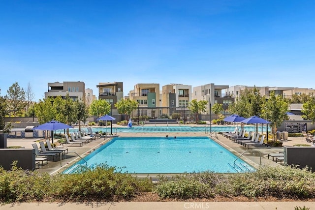 view of swimming pool with a residential view and fence