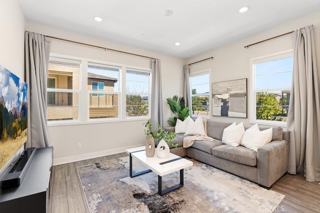 living area featuring baseboards, recessed lighting, and wood finished floors