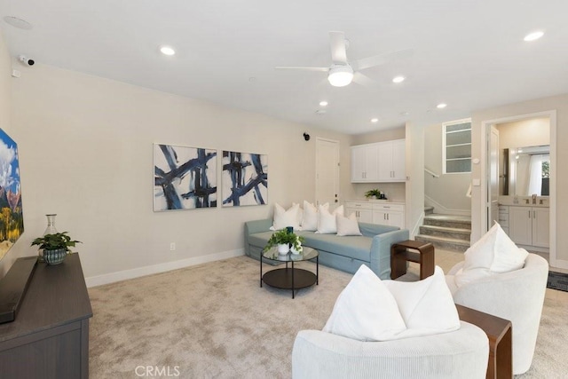 living room with baseboards, a ceiling fan, recessed lighting, stairs, and light colored carpet