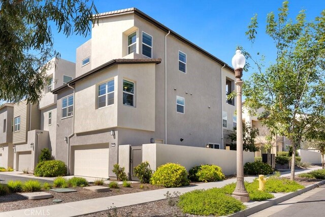 108 Shear, Irvine, CA 92618 - view of side of property with an attached garage, stucco siding, and fence