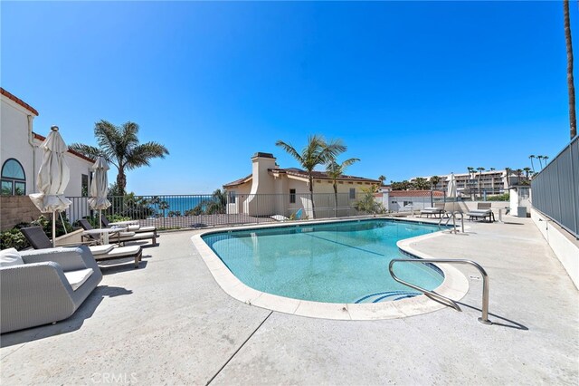 community pool featuring fence and a patio area