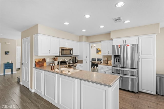 6816 Ridgeside Dr, Riverside, CA 92506 - kitchen featuring stainless steel appliances, a sink, dark wood-type flooring, a peninsula, and recessed lighting
