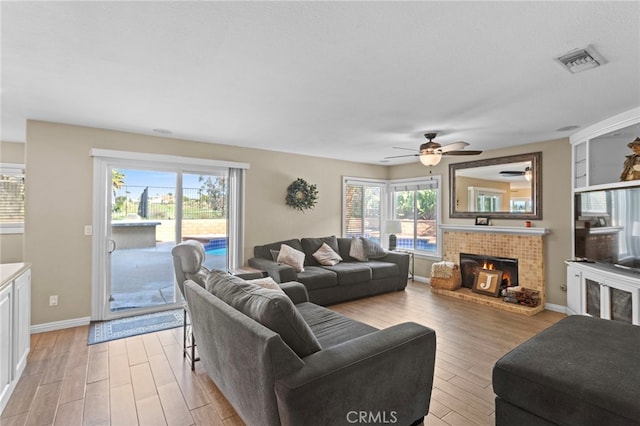 6816 Ridgeside Dr, Riverside, CA 92506 - living area featuring light wood-type flooring, a ceiling fan, baseboards, and a fireplace