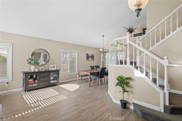 6816 Ridgeside Dr, Riverside, CA 92506 - foyer entrance with stairway, a chandelier, wood finished floors, vaulted ceiling, and baseboards