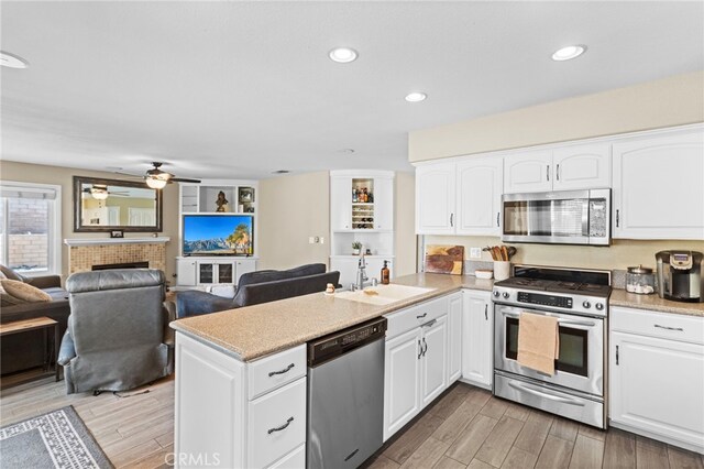 6816 Ridgeside Dr, Riverside, CA 92506 - kitchen featuring stainless steel appliances, a sink, a peninsula, light wood-type flooring, and recessed lighting