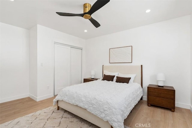 bedroom with ceiling fan, recessed lighting, baseboards, wood finished floors, and a closet