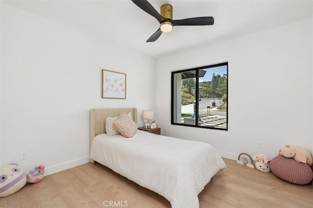 bedroom with baseboards, a ceiling fan, and wood finished floors